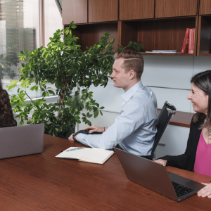 Three Gildan employees sitting around a conference table in an office