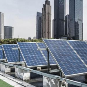 A row of tilted solar panels, a city-scape behind them