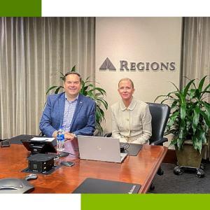 Andrew and Tara sitting at a table sharing a computer