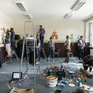 Multiple people decorating a room