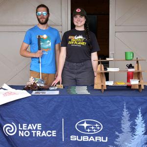 Two people stood behind an event table 