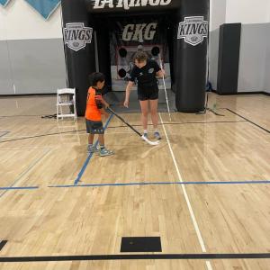 Representatives from LA Kings Hockey Development teaching a child  hockey puck shoot