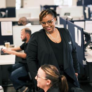 LaQuitta Ghent in an office setting, smiling at another.