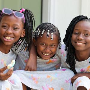 Three of Latonya's daughters in matching outfits smiling