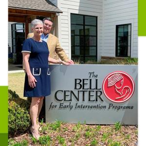 Lee and Jeff Taylor in front of a sign for "The Bell Center"
