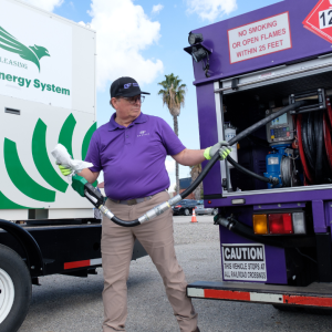 A Booster service provider holds the nozzle from Booster tanker near a mobile energy solution.
