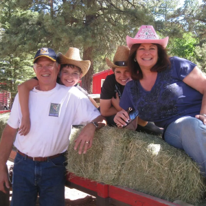 Lori and her family shown at a farm on a hayride.