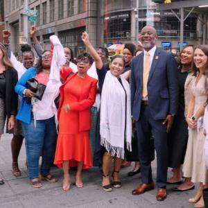 Group of people pose outside of the NASDAQ building