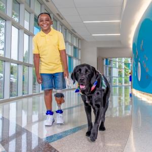 A young cancer patient with his companion dog.