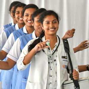 people holding up vaccinations