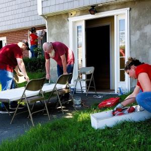 KeyBank volunteers shown working on the exterior of a home.