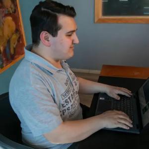 visually impaired person with their palms resting on a BlindLook laptop