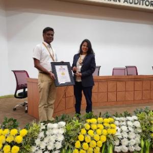 Two people on a stage holding a plaque.