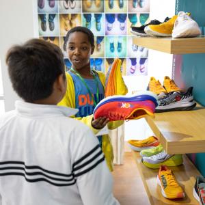 children holding Hoka shoes