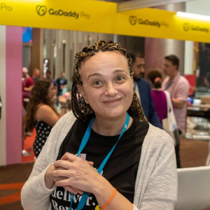 Maja smiling in front of the GoDaddy pro booth.