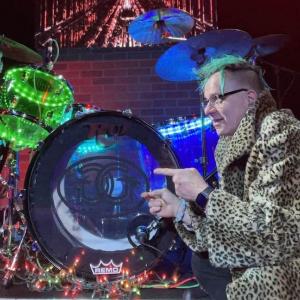 HARMAN employee having a discussion in front of a drum kit.