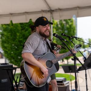  A person playing an acoustic guitar on stage.