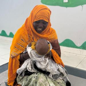 Maria plays with her grandson at the stabilization center. 