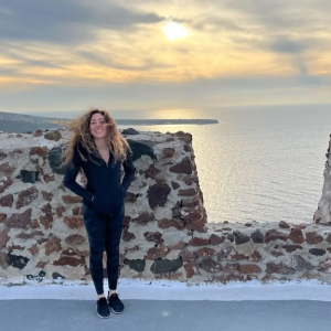 Mandy shown by a stone wall overlooking the ocean.