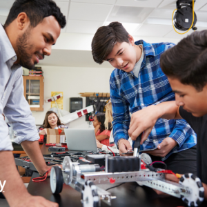 Student working with teacher on building a machine