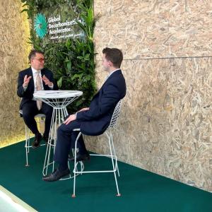 Two seated people talking.