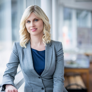 Martina Flemstrom leaning against a window sill in an office setting.