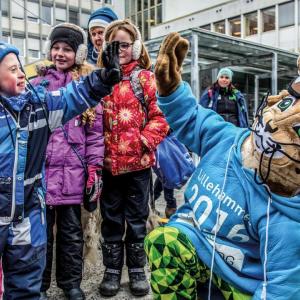 A mascott high-fiving a young child 
