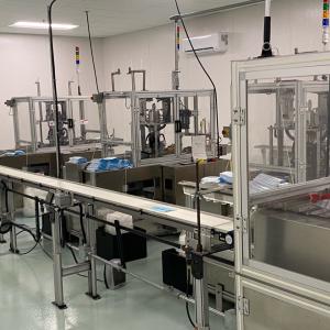 Masks being created on a conveyer belt ready to be packed and distributed.