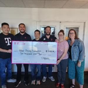 A group of people holding a donation cheque for Maui Strong Foundation