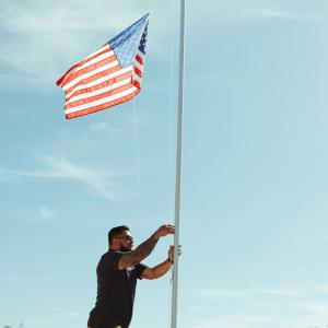 Maverick raising a flag in front of his new home.
