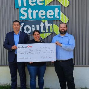 Maine Tree Street Youth team leaders with KeyBank market rep shown holding a grant check.