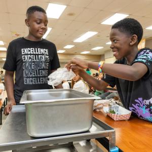 Students put food waste into a tray. © WWF-US/Rebecca Drobis