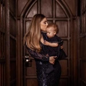 Michaela holding and kissing her daughter.