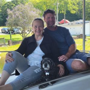 Two people smiling with dog