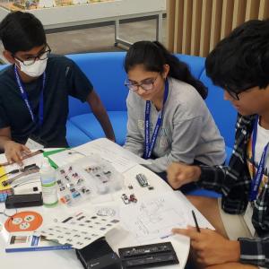 three students sitting and working together 