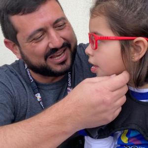 A child wearing glasses looking towards and adult