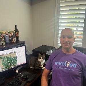 person wearing an "Involved" t-shirt and sitting at their desk