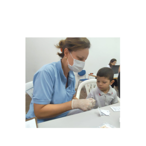An adult in medical uniform giving a child a cup.