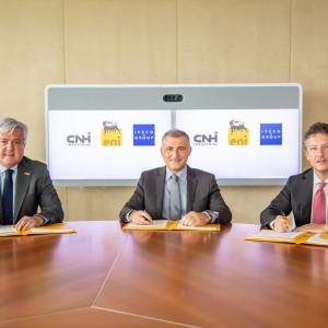 Three people at a table, signing the MOU