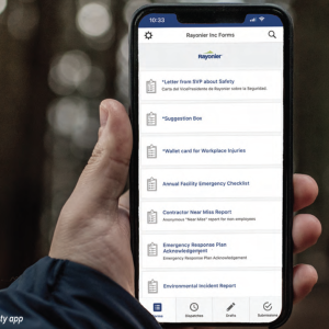 A person holding a mobile phone with the Rayonier mobile safety app open
