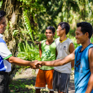 men shaking hands in forest