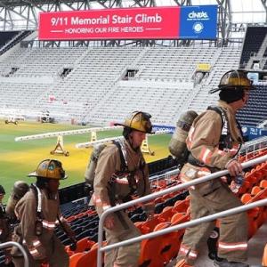 firefighters climbing stairs in a stadium 