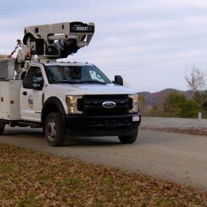 A Newport Utilities bucket truck on a road