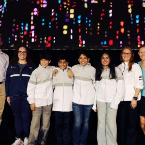 A group of students stood together for a photo with adults either side 