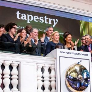 Joanne Crevoiserat ringing the opening bell at the NYSE. A team of people behind her.