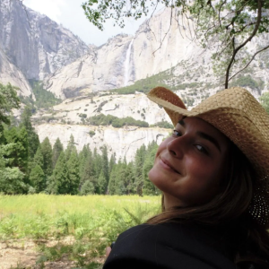 Natalie wearing a straw hat and looking at a canyon.