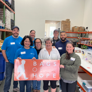 Group holding Bags of Hope sign