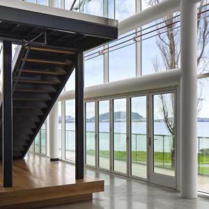 Interior of an office building with lots of windows and natural light. An open staircase central in the space.