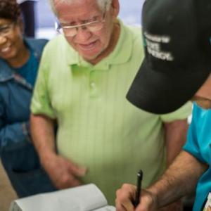 Two residents speaking with a Duke Energy employee who is taking notes on a clipboard
