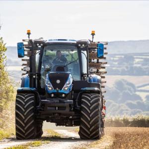 A tractor driving on a path next to a field.